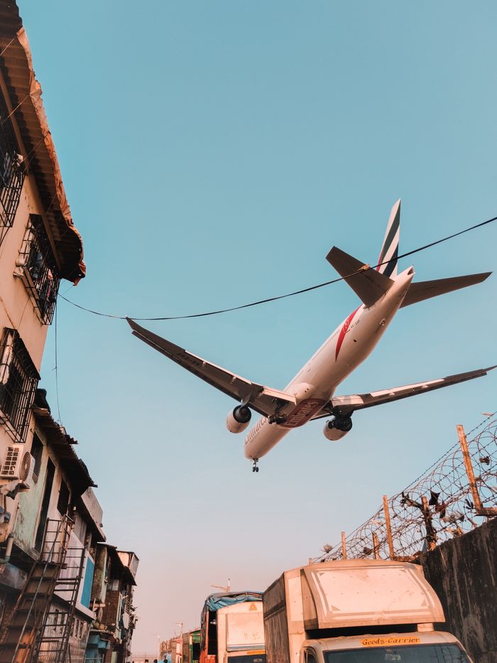 Home Airplane flying low over a busy urban street, showcasing dynamic transportation and aviation.