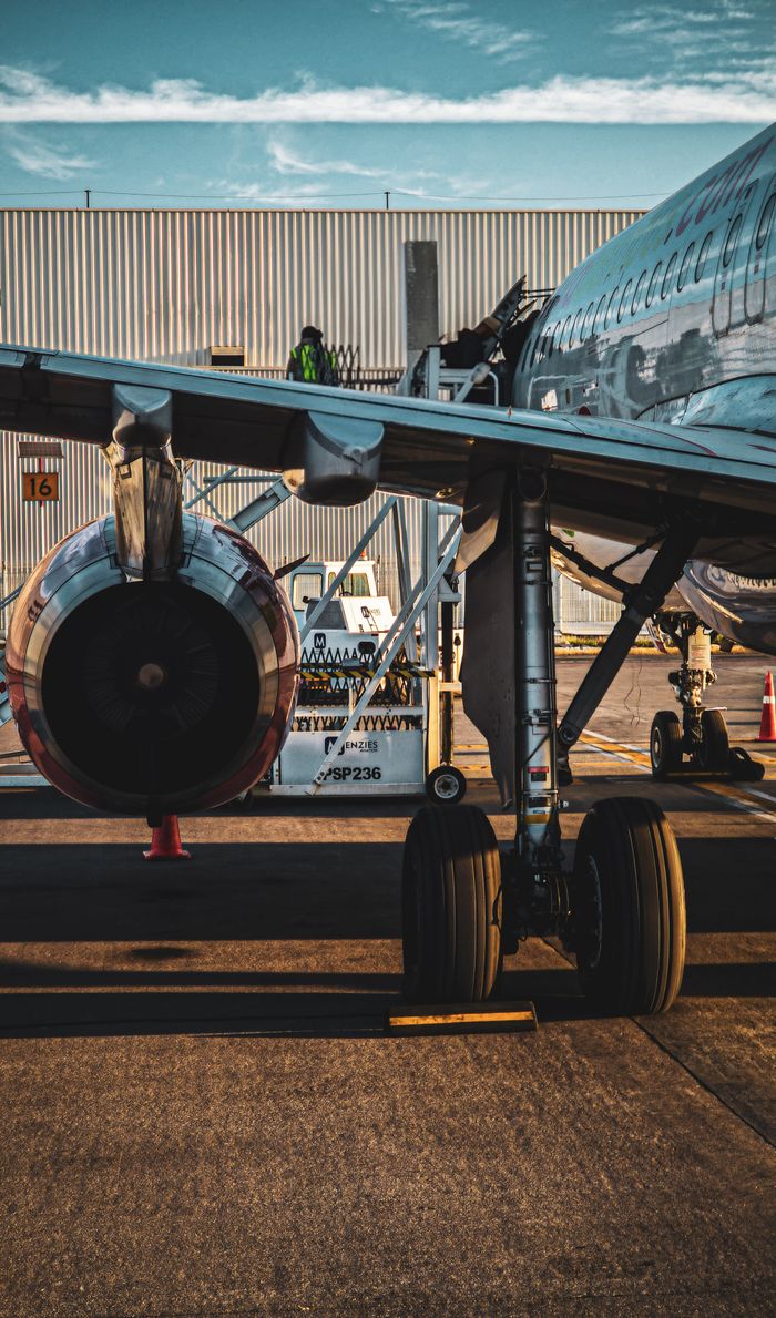 Home Close-up of a modern jet aircraft parked outside an airport hangar, highlighting engineering details.
